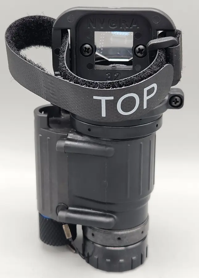 The NVGRA-14, an injection-molded adapter with a TOP strap, clamped on a PVS-14 night vision monocular